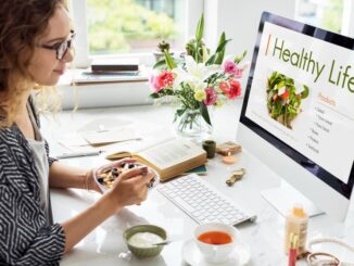 Femme prenant un petit-déjeuner sain devant son ordinateur pour trouver des solutions bien-être au quotidien sans dépasser son budget.
