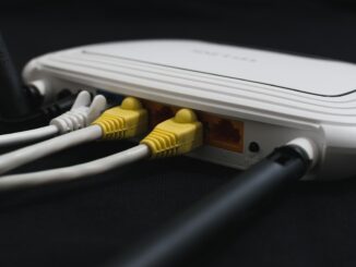 Un routeur blanc avec trois câbles branchés sur ses ports LAN