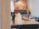 Un bureau avec ordinateur, cactus, chaise et tableau mural