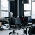 Un bureau moderne avec plusieurs écrans, chaises et lumière naturelle