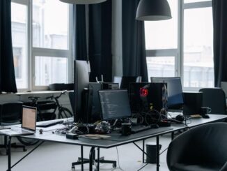 Un bureau moderne avec plusieurs écrans, chaises et lumière naturelle