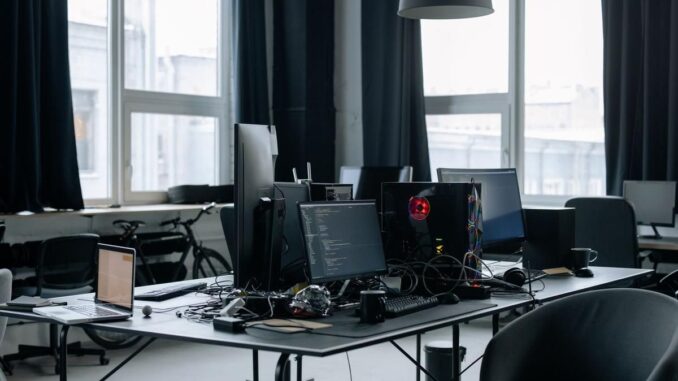 Un bureau moderne avec plusieurs écrans, chaises et lumière naturelle